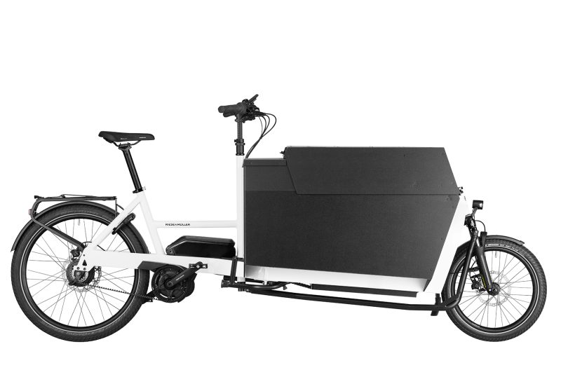 A white Riese and Muller Transporter2 85 vario cargo bike with flat covered box