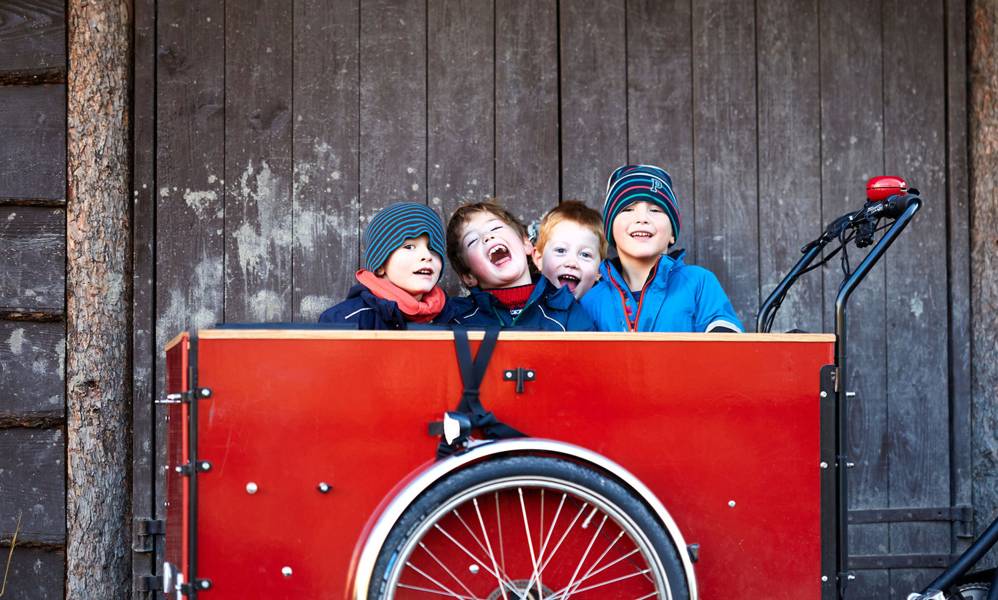 Children sitting in a red Christiania Long Box