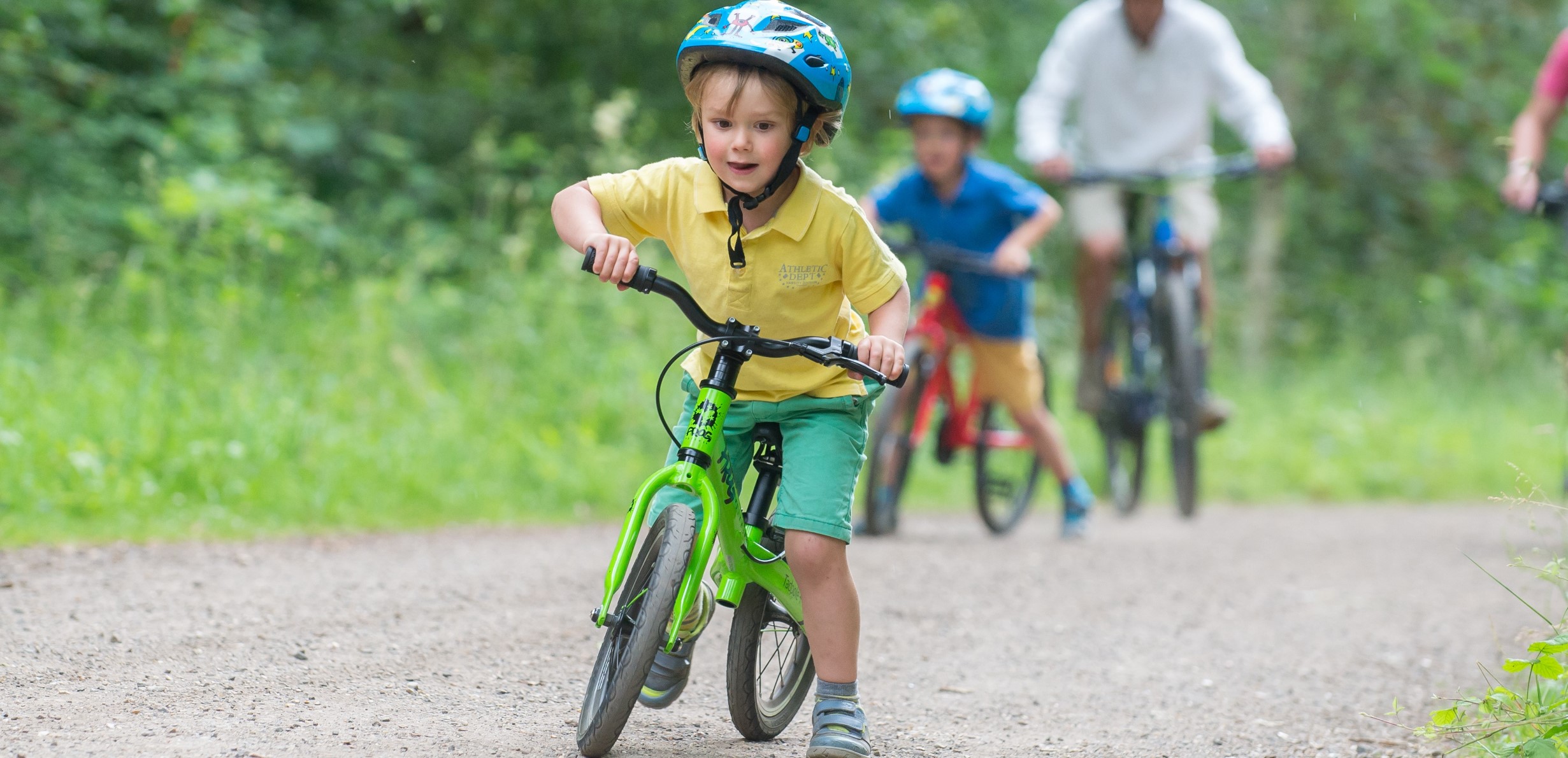 A child riding a green Frog Tadpole Plus bike